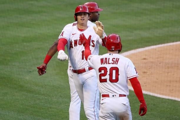 Shohei Ohtani and Jared Walsh of the Los Angeles Angels celebrate runs scored off a two RBI double by Anthony Rendon during the third inning against...