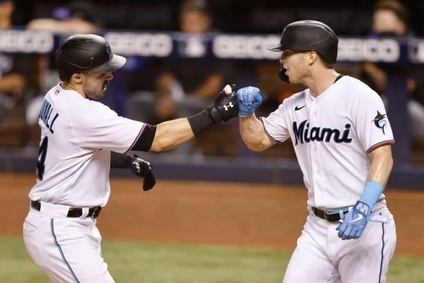 Adam Duvall of the Miami Marlins celebrates with Corey Dickerson after hitting a two-run home run against the Colorado Rockies during the seventh...