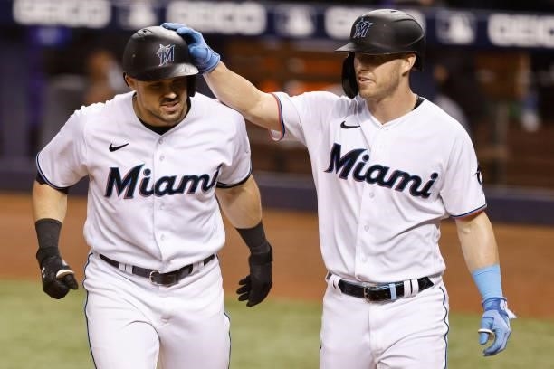 Adam Duvall of the Miami Marlins celebrates with Corey Dickerson after hitting a two-run home run against the Colorado Rockies during the seventh...