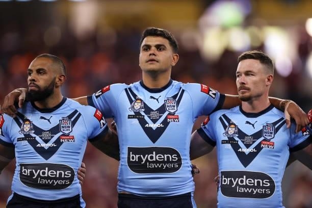 Josh Addo-Carr and Latrell Mitchell and Damien Cook of the Blues prepare for the anthem during game one of the 2021 State of Origin series between...