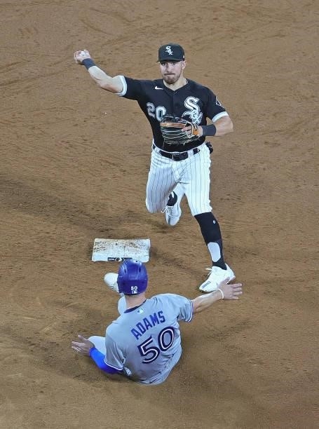 Danny Mendick of the Chicago White Sox attempts to turn a double play over Riley Adams of the Toronto Blue Jays but a fielding error at first base...