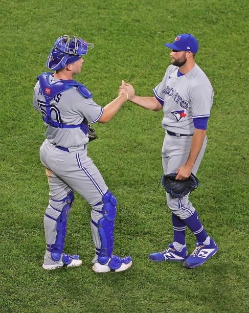 Riley Adams and Tim Mayza of the Toronto Blue Jays celebrate a win over the Chicago White Sox at Guaranteed Rate Field on June 09, 2021 in Chicago,...
