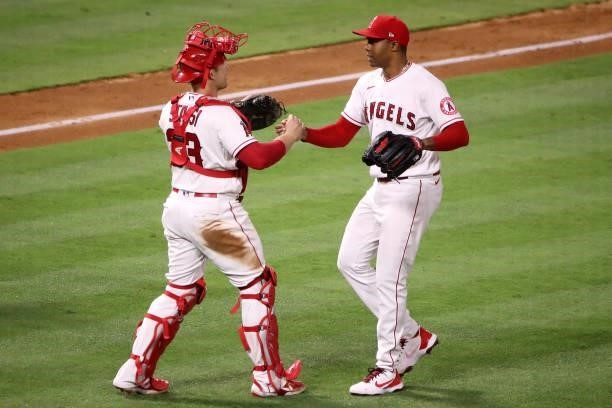 Max Stassi and Raisel Iglesias of the Los Angeles Angels celebrate their 6-1 win against the Kansas City Royals after the game at Angel Stadium of...