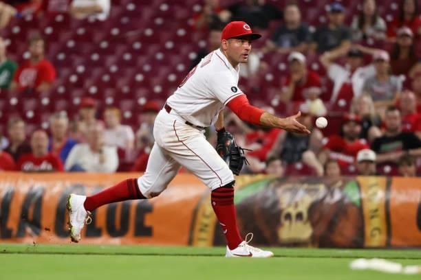 Joey Votto of the Cincinnati Reds tosses the ball to first base in the eighth inning against the Milwaukee Brewers at Great American Ball Park on...