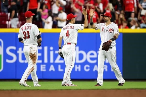 Jesse Winker, Shogo Akiyama, and Nick Castellanos of the Cincinnati Reds celebrate after beating the Milwaukee Brewers 7-3 at Great American Ball...