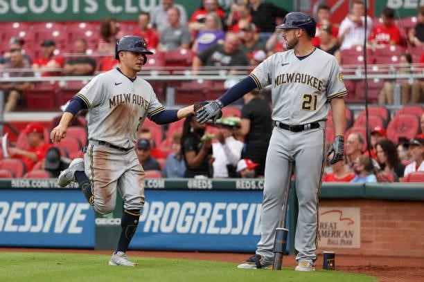 Luis Urias and Travis Shaw of the Milwaukee Brewers celebrate after Urias scored a run in the first inning against the Cincinnati Reds at Great...
