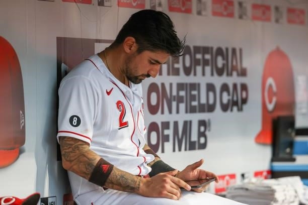 Nick Castellanos of the Cincinnati Reds uses a tablet in the fourth inning against the Milwaukee Brewers at Great American Ball Park on June 09, 2021...