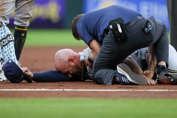 Travis Shaw of the Milwaukee Brewers is attended to after being injured in the second inning against the Cincinnati Reds at Great American Ball Park...