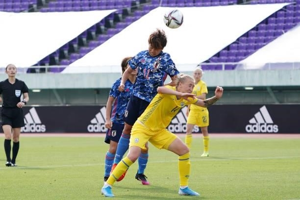 Mina Tanaka of Japan and Liubov Shmatko of Ukraine compete for the ball during the women's international friendly match between Japan and Ukraine at...