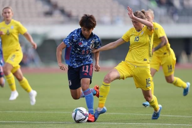 Mina Tanaka of Japan and Kateryny Korsun of Ukraine compete for the ball during the women's international friendly match between Japan and Ukraine at...