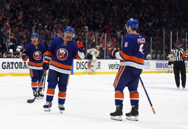 Andy Greene of the New York Islanders congratulates Ryan Pulock on his empty net goal against the Boston Bruins in Game Six of the Second Round of...