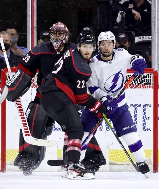 Alex Nedeljkovic of the Carolina Hurricanes stands tall in the crease as teammates Brett Pesce battles near the crease with Tyler Johnson of the...