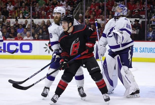 Jesper Fast of the Carolina Hurricanes battles for position near the crease with David Savard of the Tampa Bay Lightning as Andrei Vasilevskiy stands...