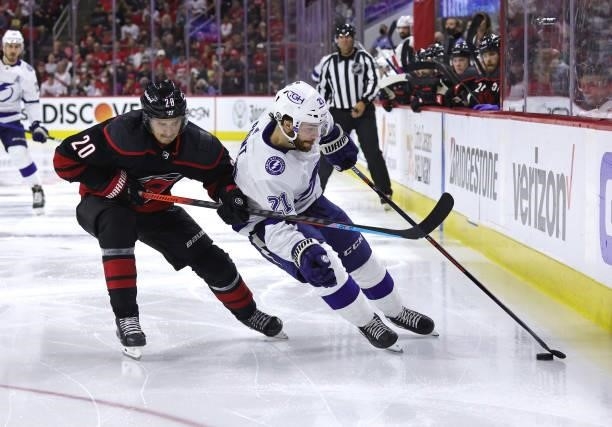 Brayden Point the Tampa Bay Lightning controls the puck away from the defense of Sebastian Aho in Game Five of the Second Round of the 2021 Stanley...