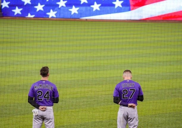 Ryan McMahon and Trevor Story of the Colorado Rockies stand during the National Anthem prior to the game against the Miami Marlins at loanDepot park...