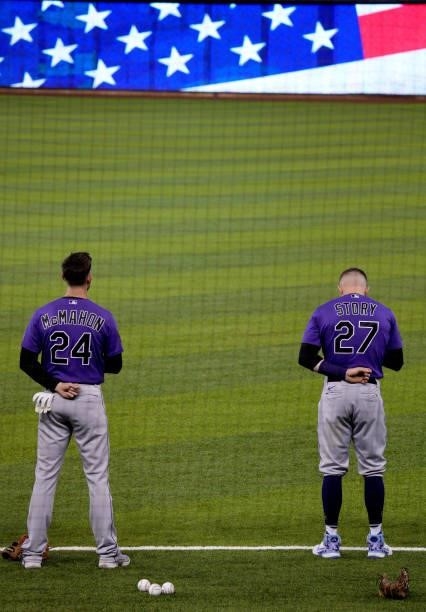 Ryan McMahon and Trevor Story of the Colorado Rockies stand during the National Anthem prior to the game against the Miami Marlins at loanDepot park...