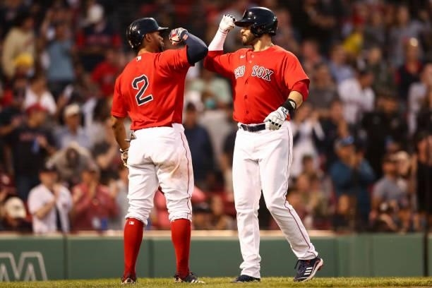Martinez reacts with Xander Bogaerts of the Boston Red Sox after hitting a solo home run in the third inning of a game against the Houston Astros at...