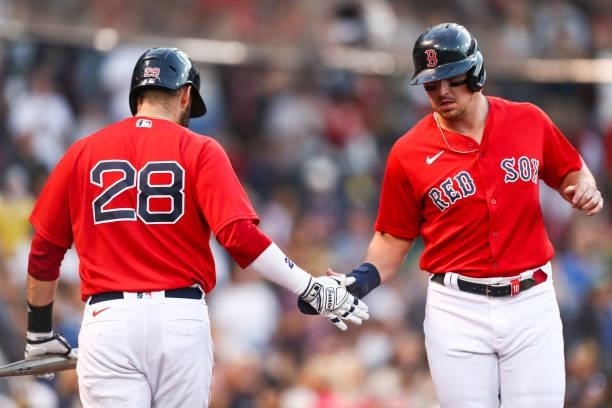 Hunter Renfroe of the Boston Red Sox high fives J.D. Martinez of the Boston Red Sox after scoring during a game against teh Houston Astros at Fenway...