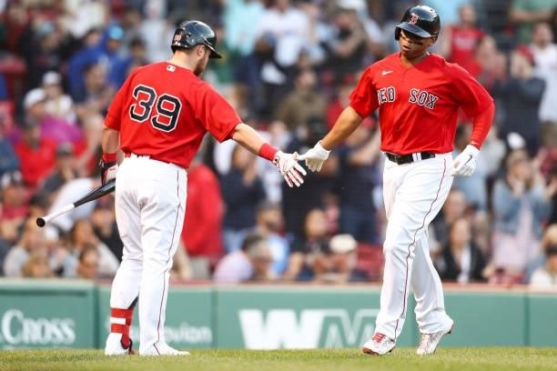 Rafael Devers high fives Christian Arroyo of the Boston Red Sox after scoring in the second inning of a game against the Houston Astros at Fenway...