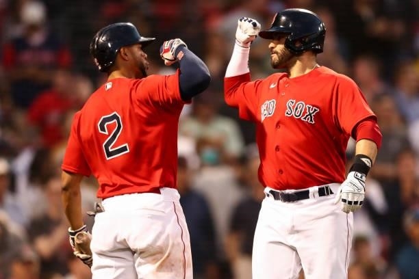 Martinez reacts with Xander Bogaerts of the Boston Red Sox after hitting a solo home run in the third inning of a game against the Houston Astros at...