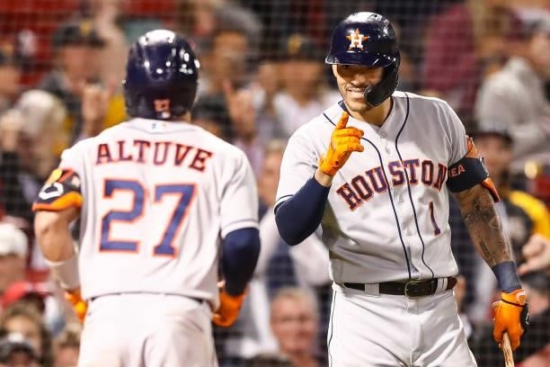 Jose Altuve reacts with Carlos Correa of the Houston Astros after hitting a solo home run in the sixth inning of a game against the Boston Red Sox at...