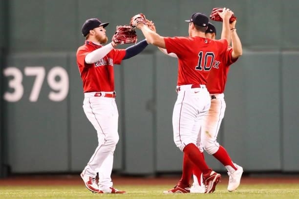 Alex Verdugo, Hunter Renfroe and Enrique Hernandez of the Boston Red Sox embrace after a win over the Houston Astros at Fenway Park on June 10, 2021...