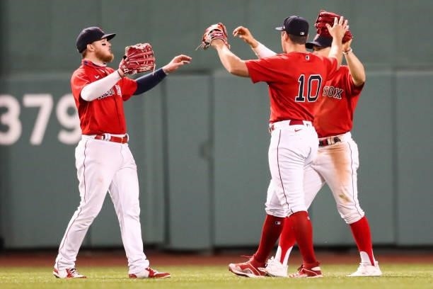 Alex Verdugo, Hunter Renfroe and Enrique Hernandez of the Boston Red Sox embrace after a win over the Houston Astros at Fenway Park on June 10, 2021...