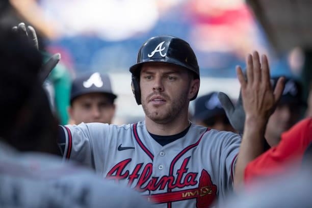 Freddie Freeman of the Atlanta Braves high fives his teammates after hitting a solo home run in the top of the ninth inning against the Philadelphia...