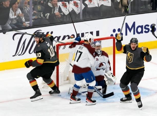 Tyson Jost of the Colorado Avalanche looks on as Nicolas Roy and Mattias Janmark of the Vegas Golden Knights celebrate after Nick Holden of the Vegas...
