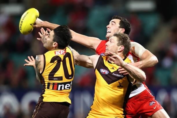 Tom McCartin of the Swans clears the ball past Ben McEvoy of the Hawks during the round 13 AFL match between the Sydney Swans and the Hawthorn Hawks...