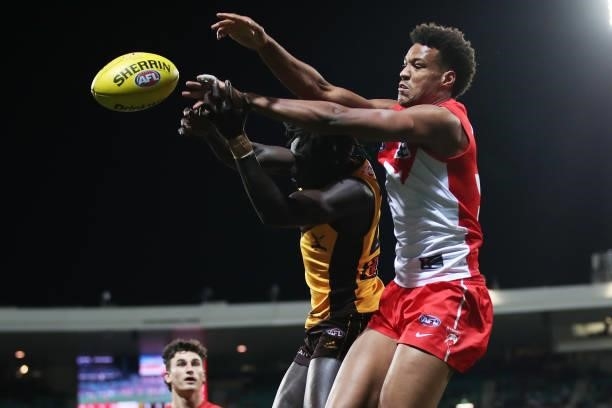 Joel Amartey of the Swans is challenged by Changkuoth Jiath of the Hawks during the round 13 AFL match between the Sydney Swans and the Hawthorn...
