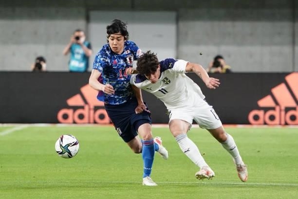 Nemanja Jovic of Serbia and Junya Ito of Japan compete for the ball during the international friendly match between Japan and Serbia at Noevir...