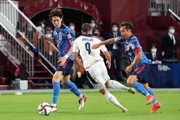 Dejan Joveljic of Serbia compete for the ball Kento Hashimoto and Yuto Nagatomo of Japan during the international friendly match between Japan and...