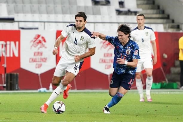 Marko Grujic of Serbia and Kento Hashimoto of Japan compete for the ball during the international friendly match between Japan and Serbia at Noevir...
