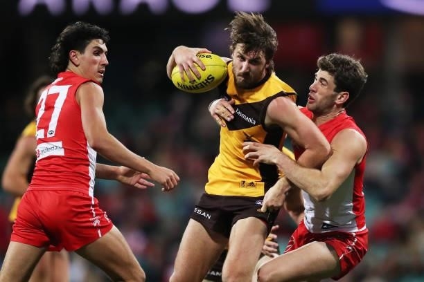 Tom Phillips of the Hawks is challenged by Robbie Fox of the Swans during the round 13 AFL match between the Sydney Swans and the Hawthorn Hawks at...