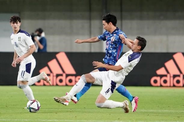 Hayao Kawabe of Japan and Nemanja Maksimovic of Serbia compete for the ball during the international friendly match between Japan and Serbia at...