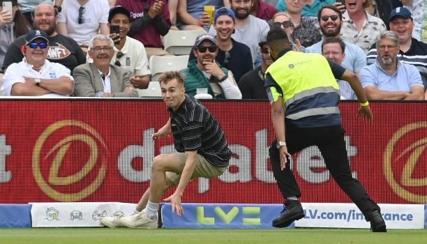 An intruder slips as he attempts to avoid stewards during the second day of the second LV= Test Match between England and New Zealand at Edgbaston on...