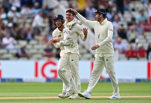 Dan Lawrence of England celebrates taking the wicket of Will Young of New Zealand with team mates James Bracey and Dominic Sibley of England during...