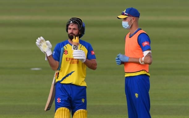 Durham batsman Ned Eckersley takes a drink off the PPE wearing 12th man during the Vitality T20 Blast match between Durham Cricket and Yorkshire...
