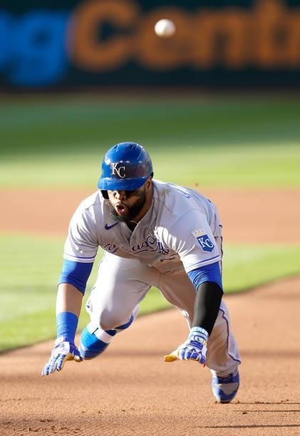 Carlos Santana of the Kansas City Royals dives back into first base safe ahead of the throw against the Oakland Athletics in the top of the first...