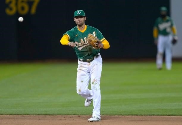 Chad Pinder of the Oakland Athletics throws to first base throwing out Carlos Santana of the Kansas City Royals in the top of the eighth inning at...