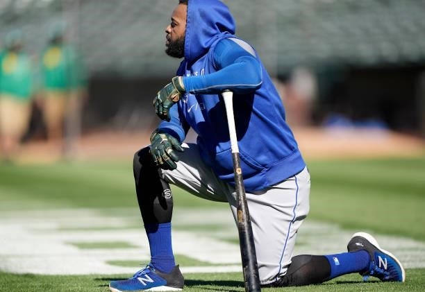 Carlos Santana of the Kansas City Royals on one knee looking on during batting practice prior to the start of his game against the Oakland Athletics...