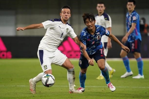 Nemanja Maksimovic of Serbia and Hidemasa Morita of Japan compete for the ball during the international friendly match between Japan and Serbia at...