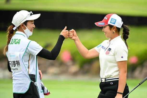 Miyuu Yamashita of Japan fist bumps with her caddie after holing out with the birdie on the 18th green during the third round of the Ai Miyazato...