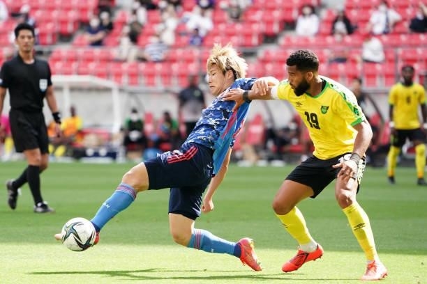 Daiki Hashioka of Japan U-24 controls the ball under pressure of Adrian Mariappa of Jamaica during the international friendly match between Japan...