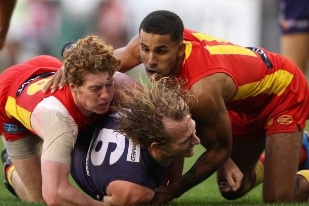 David Mundy of the Dockers gets tackled by Matt Rowell and Touk Miller of the Suns during the round 13 AFL match between the Fremantle Dockers and...