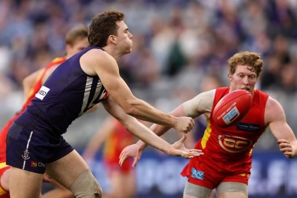Blake Acres of the Dockers handballs during the round 13 AFL match between the Fremantle Dockers and the Gold Coast Suns at Optus Stadium on June 12,...