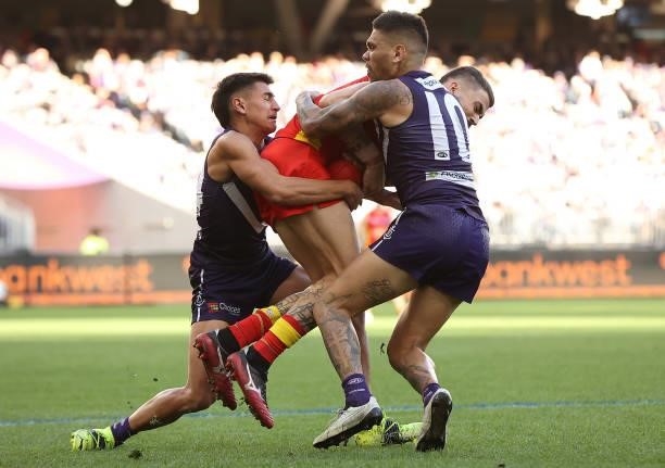 Oleg Markov of the Suns gets tackled by Joel Western and Michael Walters of the Dockers during the round 13 AFL match between the Fremantle Dockers...
