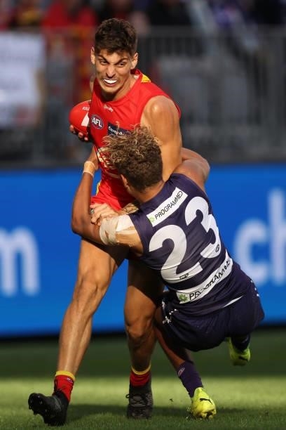 Liam Henry of the Dockers tackles Sean Lemmens of the Suns during the round 13 AFL match between the Fremantle Dockers and the Gold Coast Suns at...