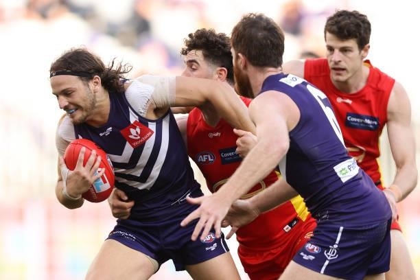 James Aish of the Dockers attempts to break from a tackle during the round 13 AFL match between the Fremantle Dockers and the Gold Coast Suns at...